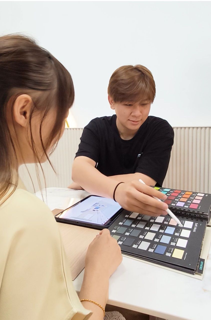 A man and a woman are sitting at a table looking at a tablet.