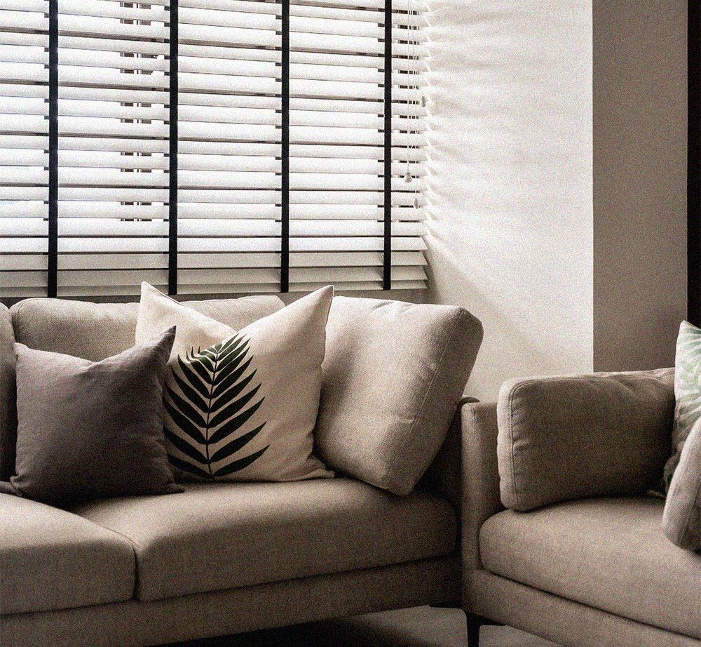 A couch with a palm leaf pillow on it
