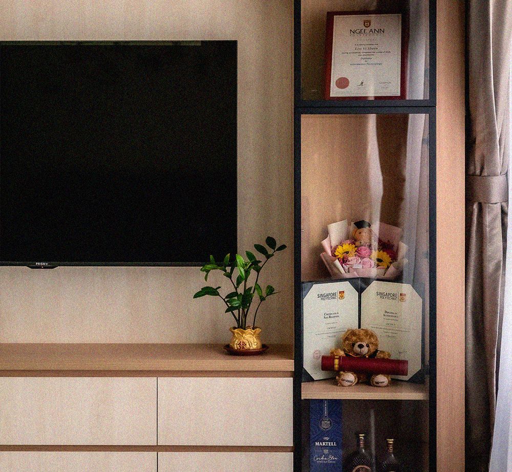 A tv is mounted on a wall next to a shelf with a certificate on it