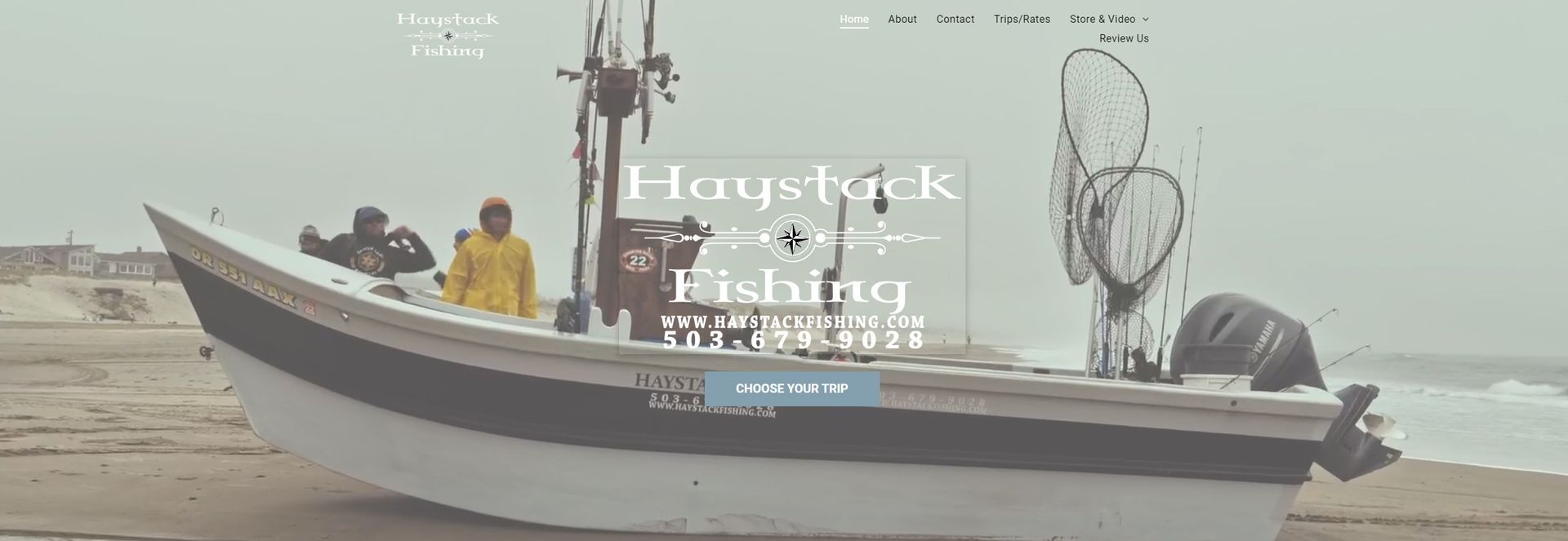 Fishing boat on the shore, two people onboard. Overcast day.