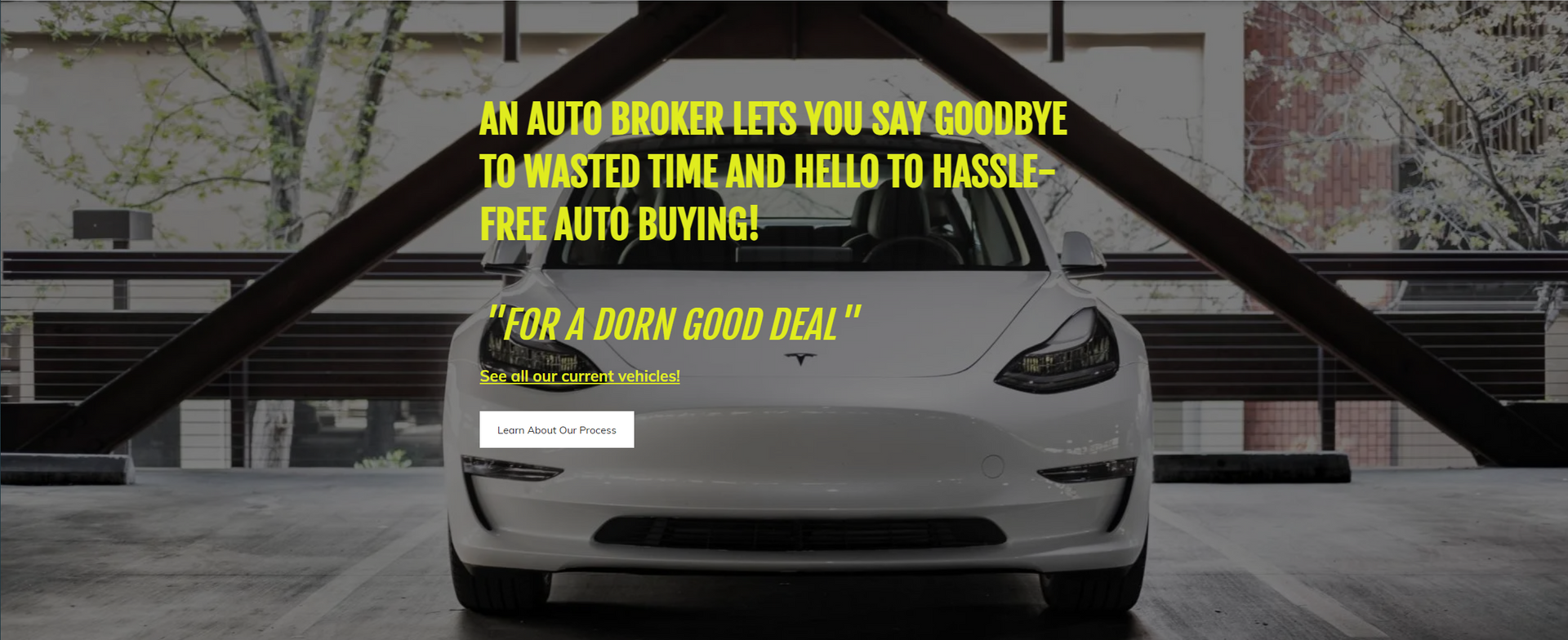 White Tesla car with text about auto broker, in a garage setting.