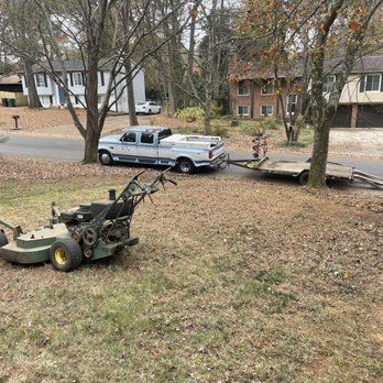 A lawn mower is being towed by a truck.