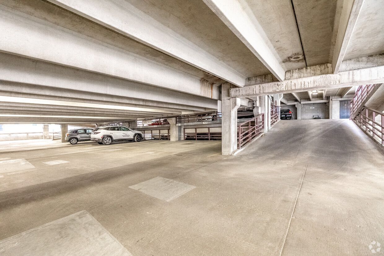 A concrete parking garage with cars parked on multiple levels.