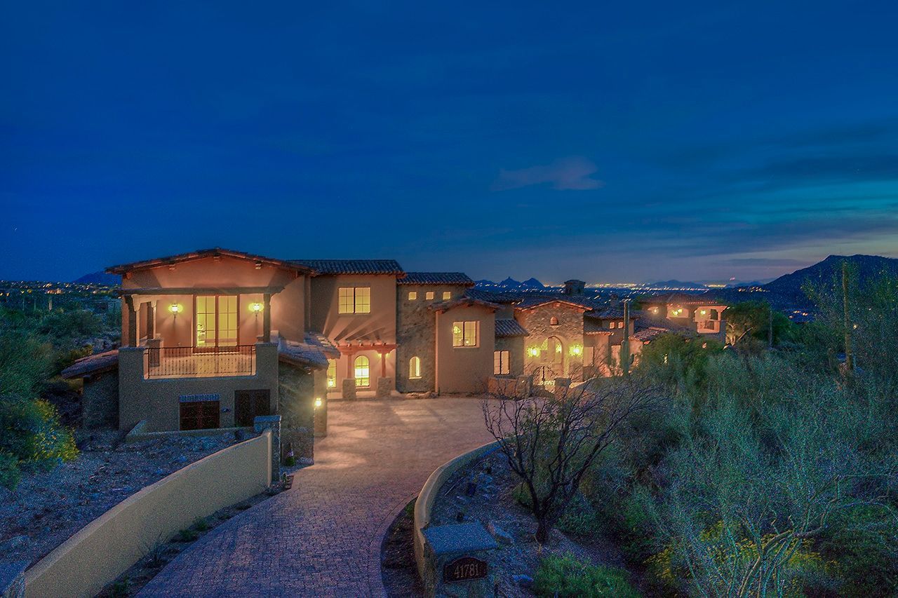 A large house with a lot of windows is lit up at night.