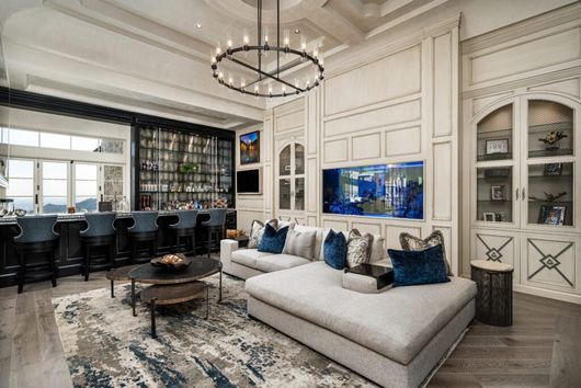 A living room with a couch , table , chairs and a fish tank.