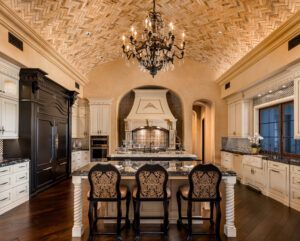 A kitchen with a large island and a chandelier hanging from the ceiling.