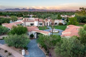 An aerial view of a large house surrounded by trees and mountains.