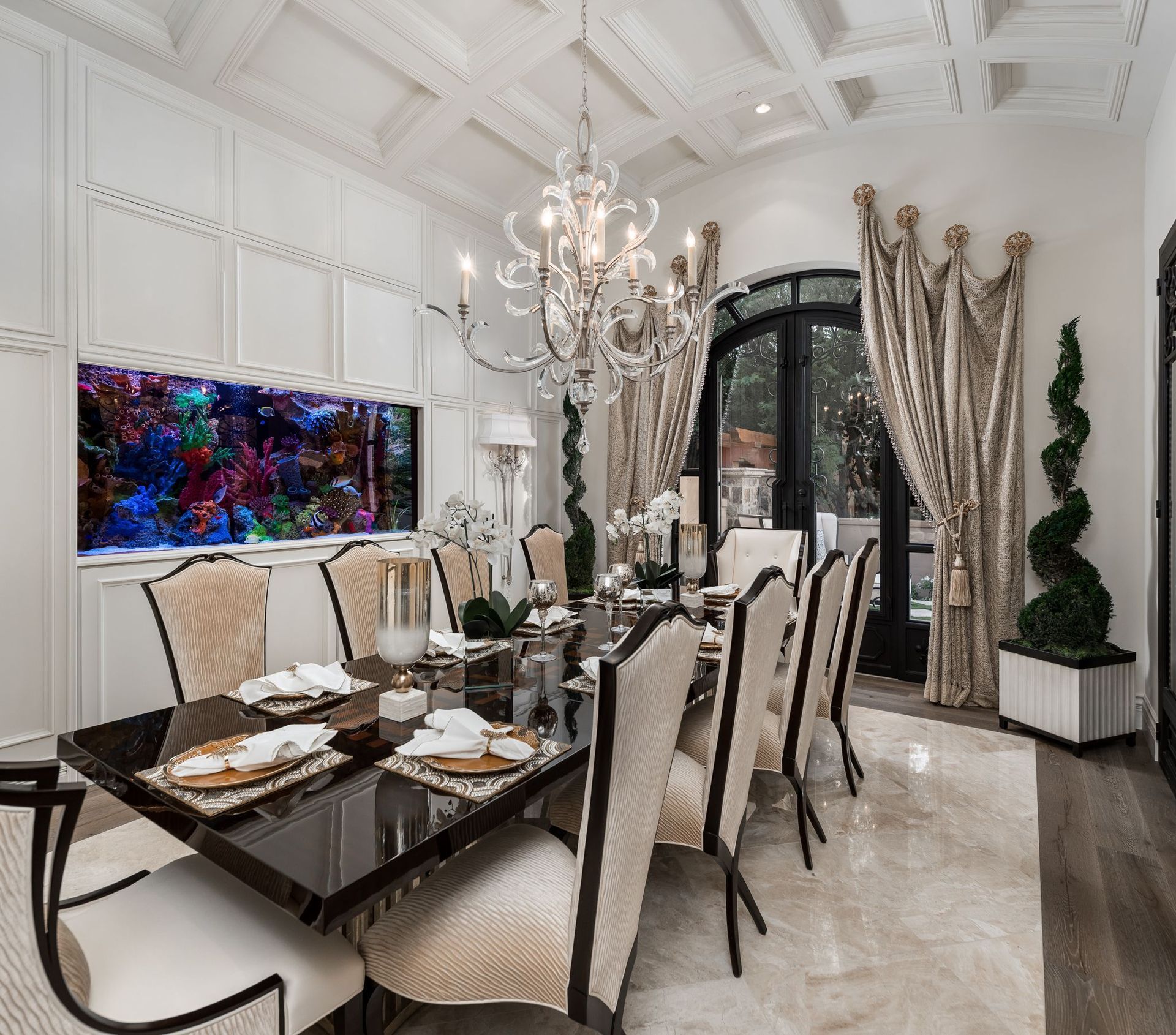 A dining room with a table and chairs and a fish tank on the wall