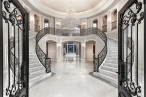 A large hallway with a spiral staircase and a chandelier.