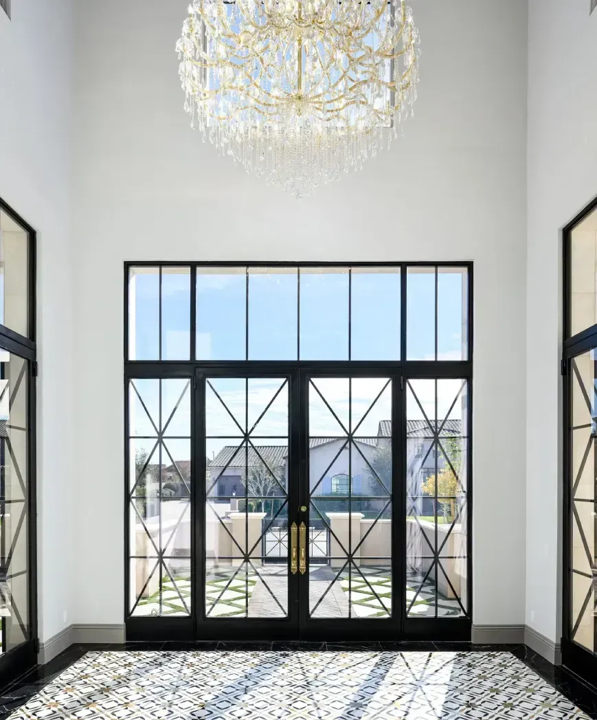 modern entryway with black glass doors and chandelier and tiled floor