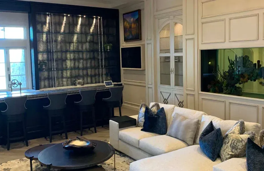 luxury home bar with built-in cabinetry chandelier lighting and bar seating