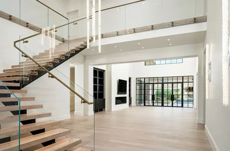 modern home entryway with floating staircase, statement lighting, and wood flooring