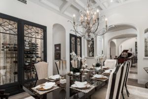 A dining room with a long table and chairs and a chandelier.