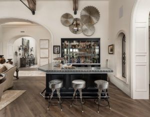There is a bar with stools in the middle of the room.