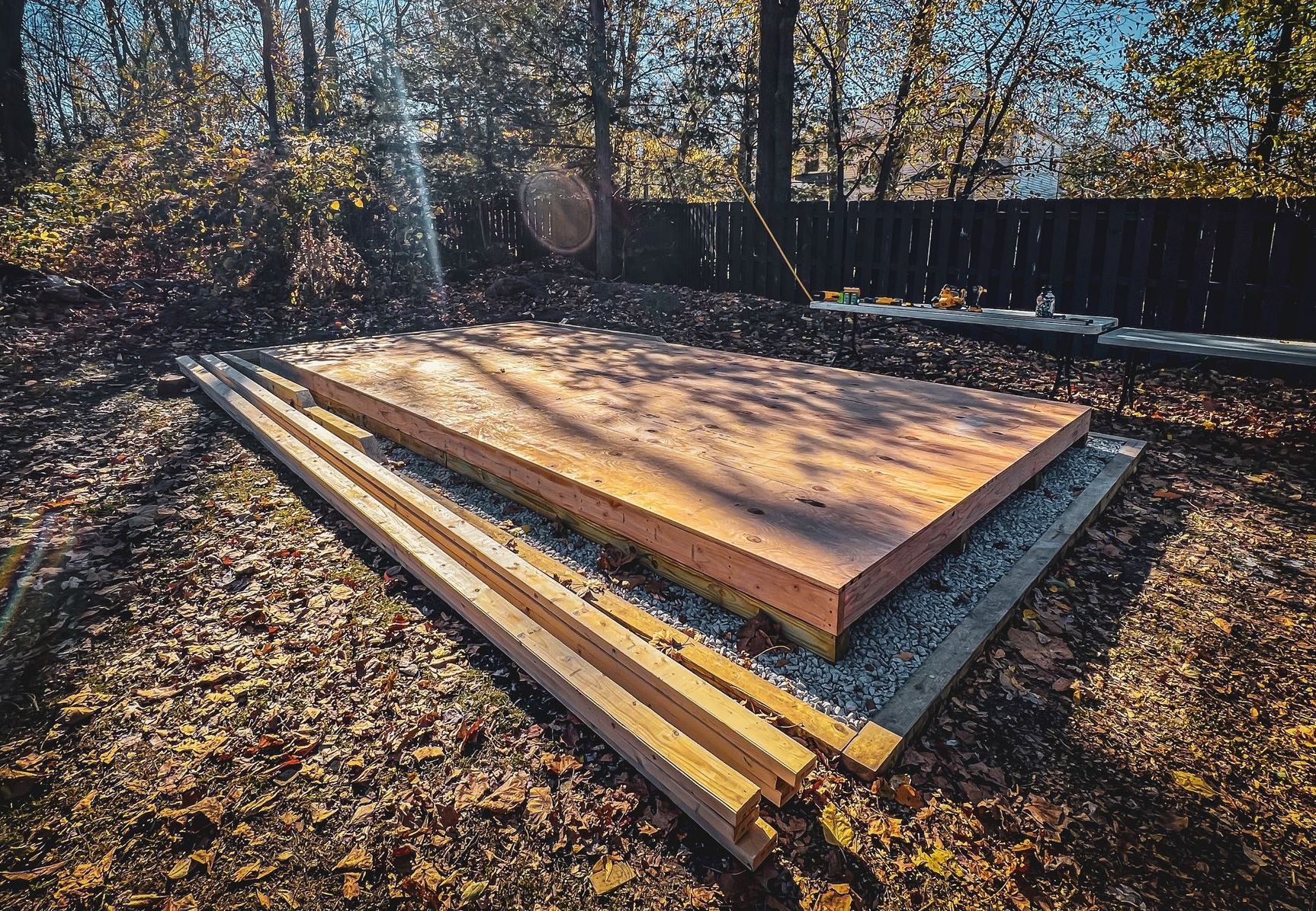 A stack of wooden boards sitting on top of each other on the ground.