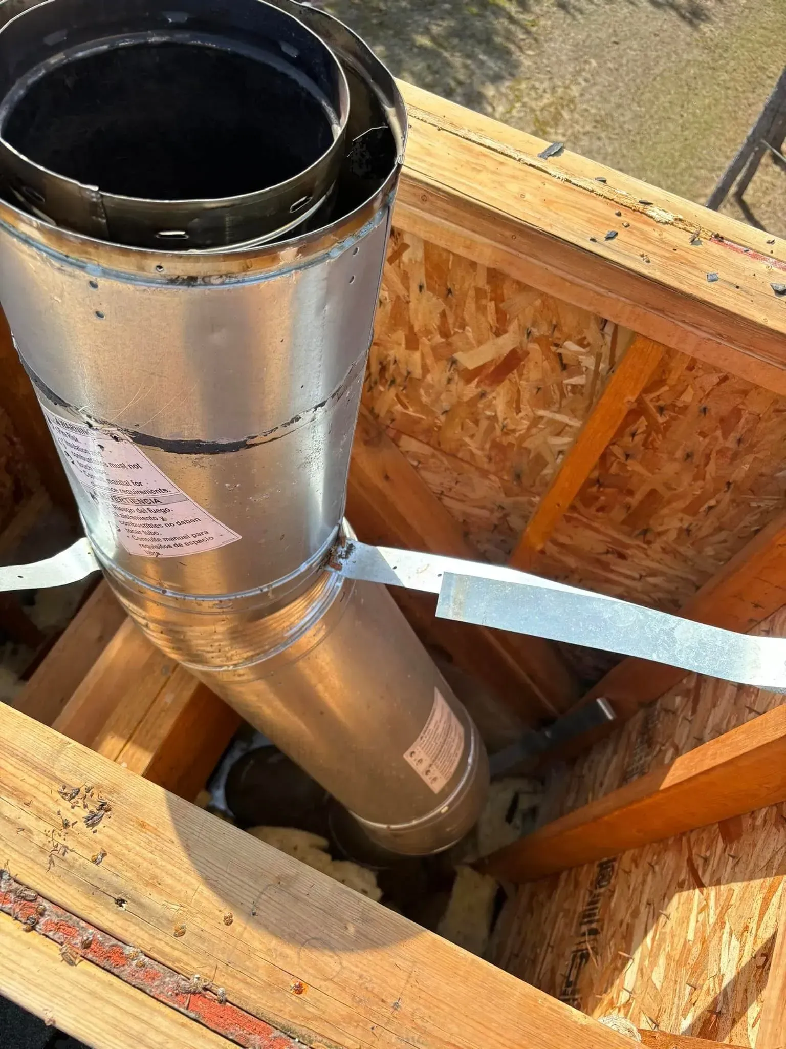 A metal pipe is sitting inside of a wooden structure.