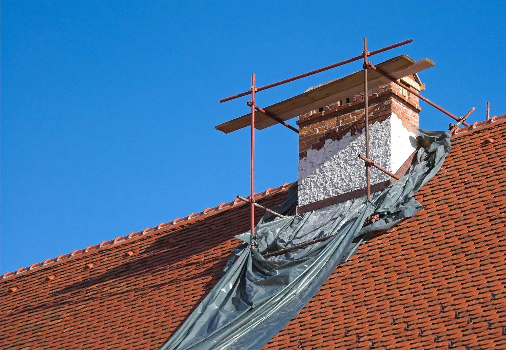 A chimney on top of a roof with scaffolding around it