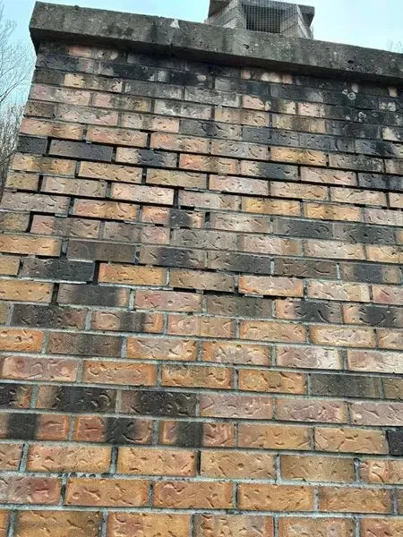 A brick wall with a chimney on top of it.