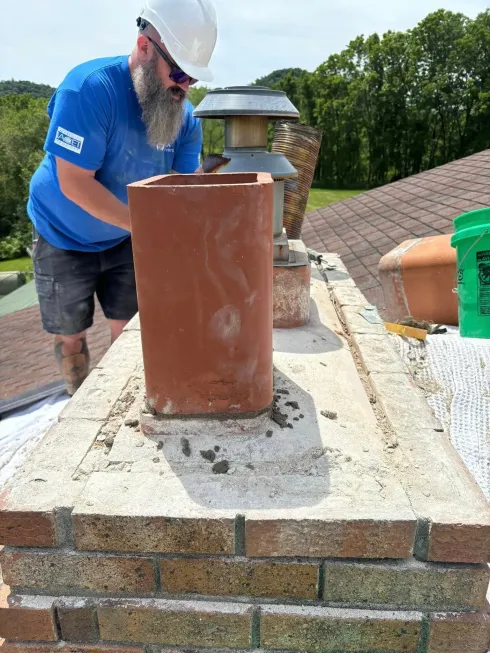 A person is cleaning an air conditioner with a high pressure washer.