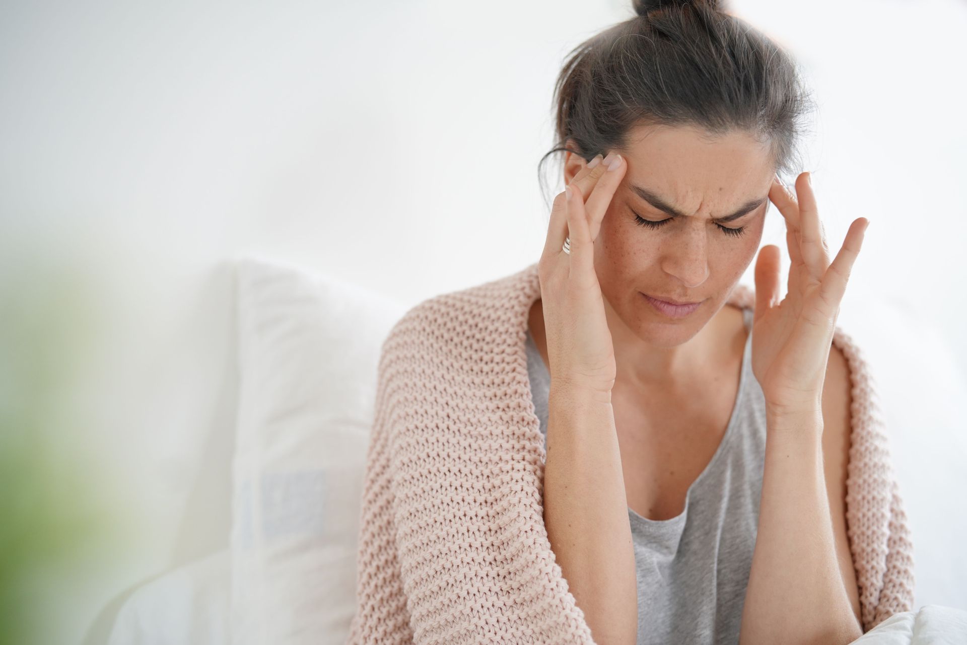 Young woman holding her head in pain, experiencing a headache