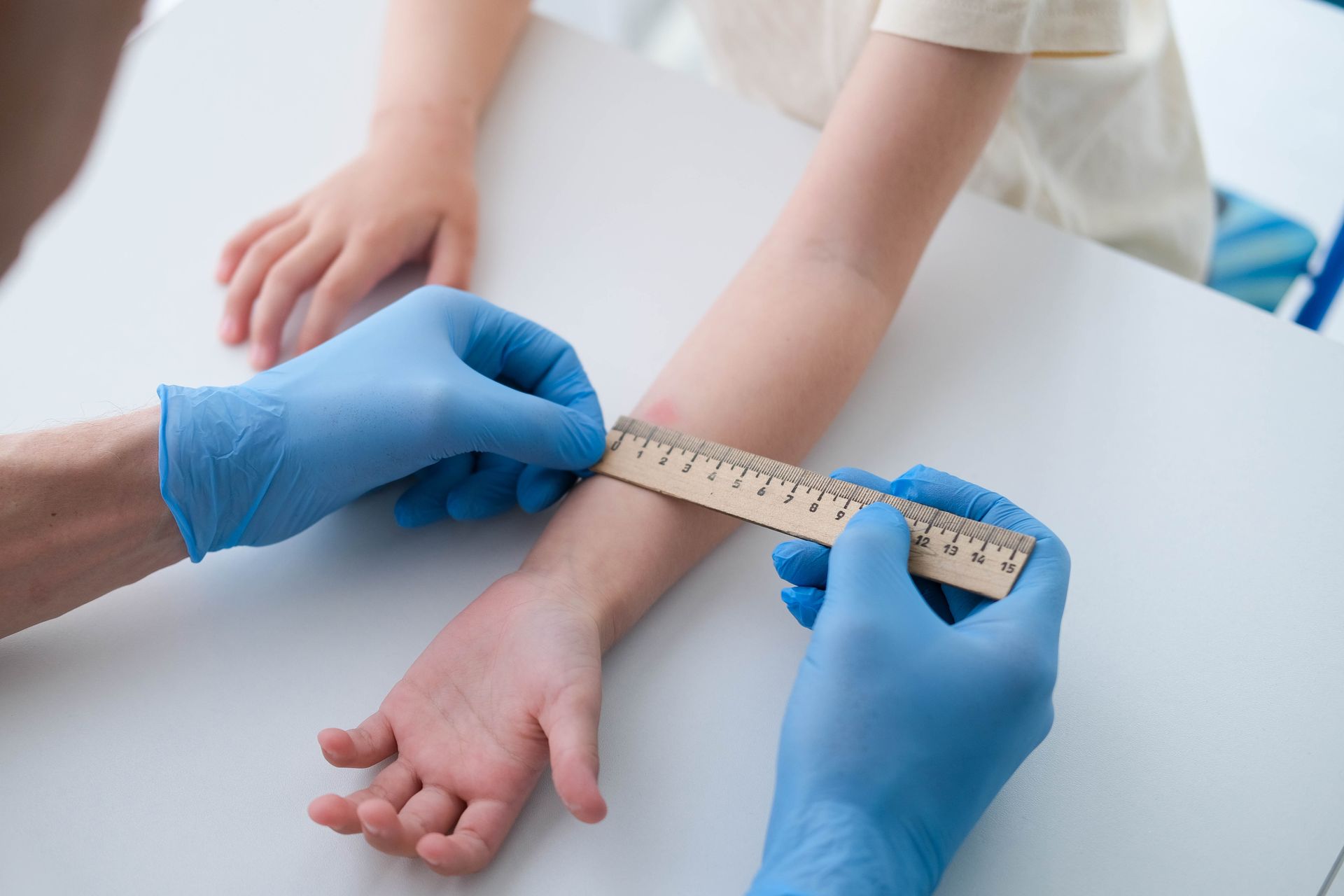 A doctor is measuring a child 's wrist with a ruler.