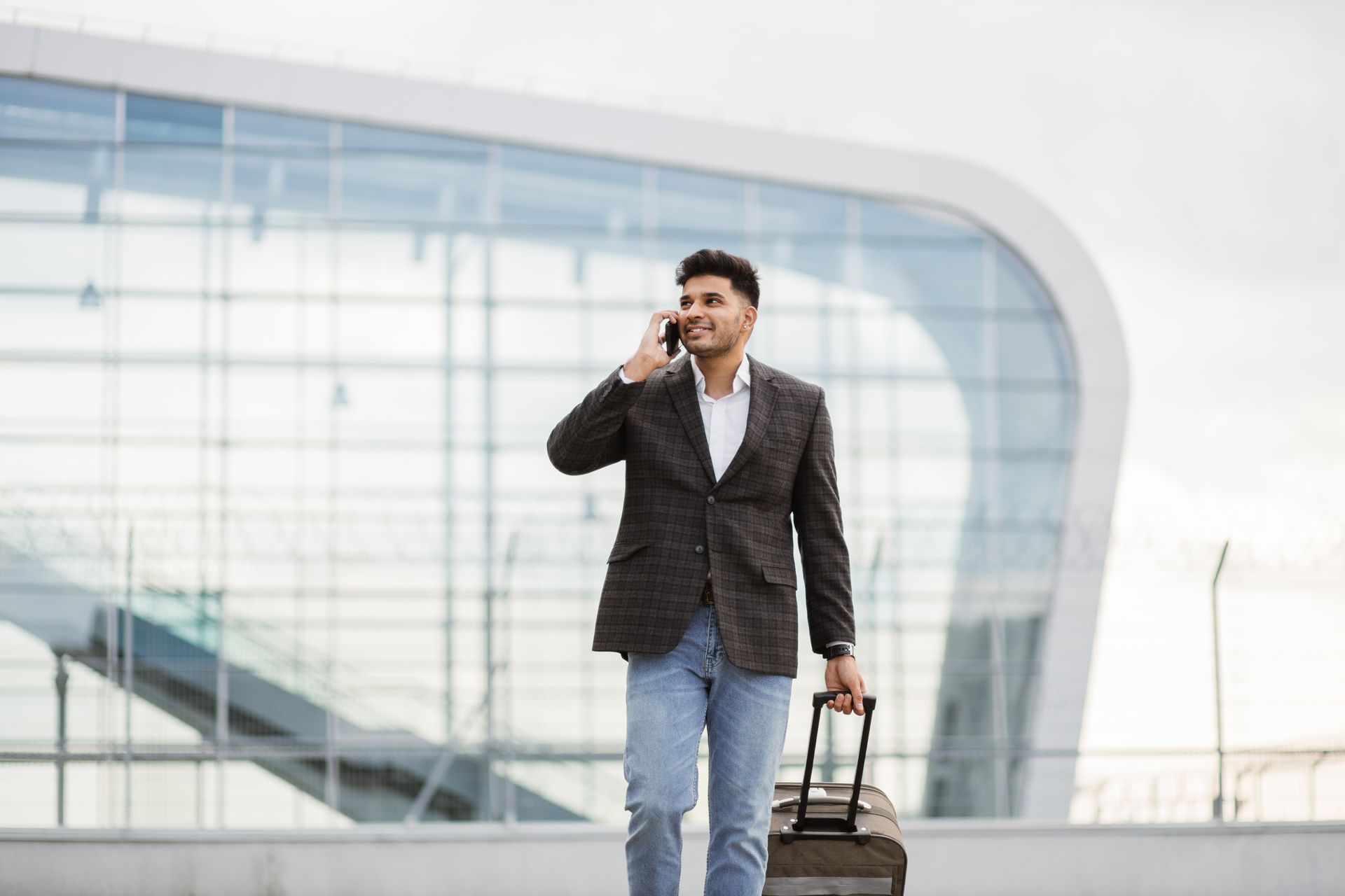 young man walking at the airport with his suitcase