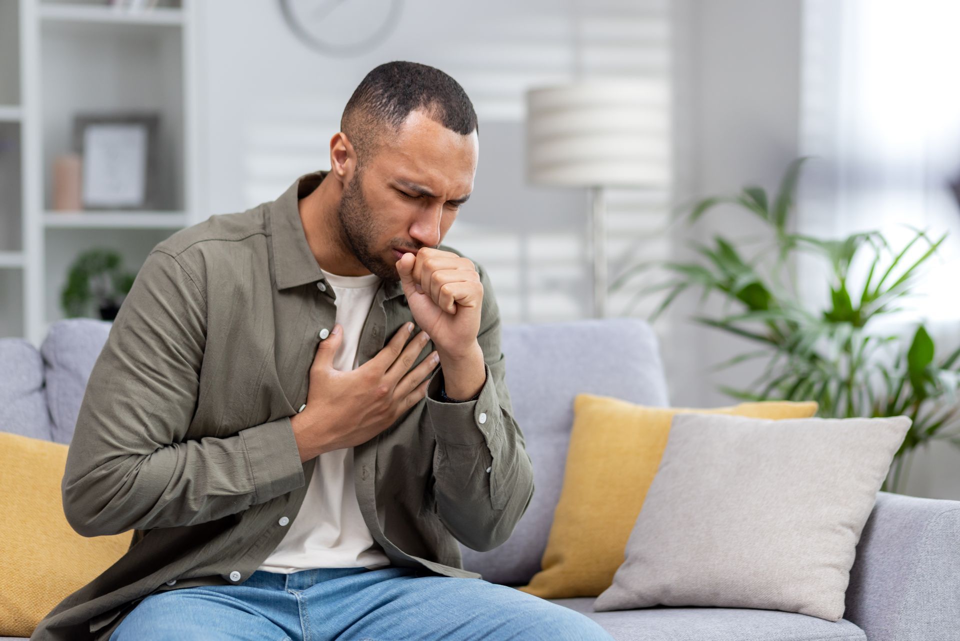 young man at home coughing on couch