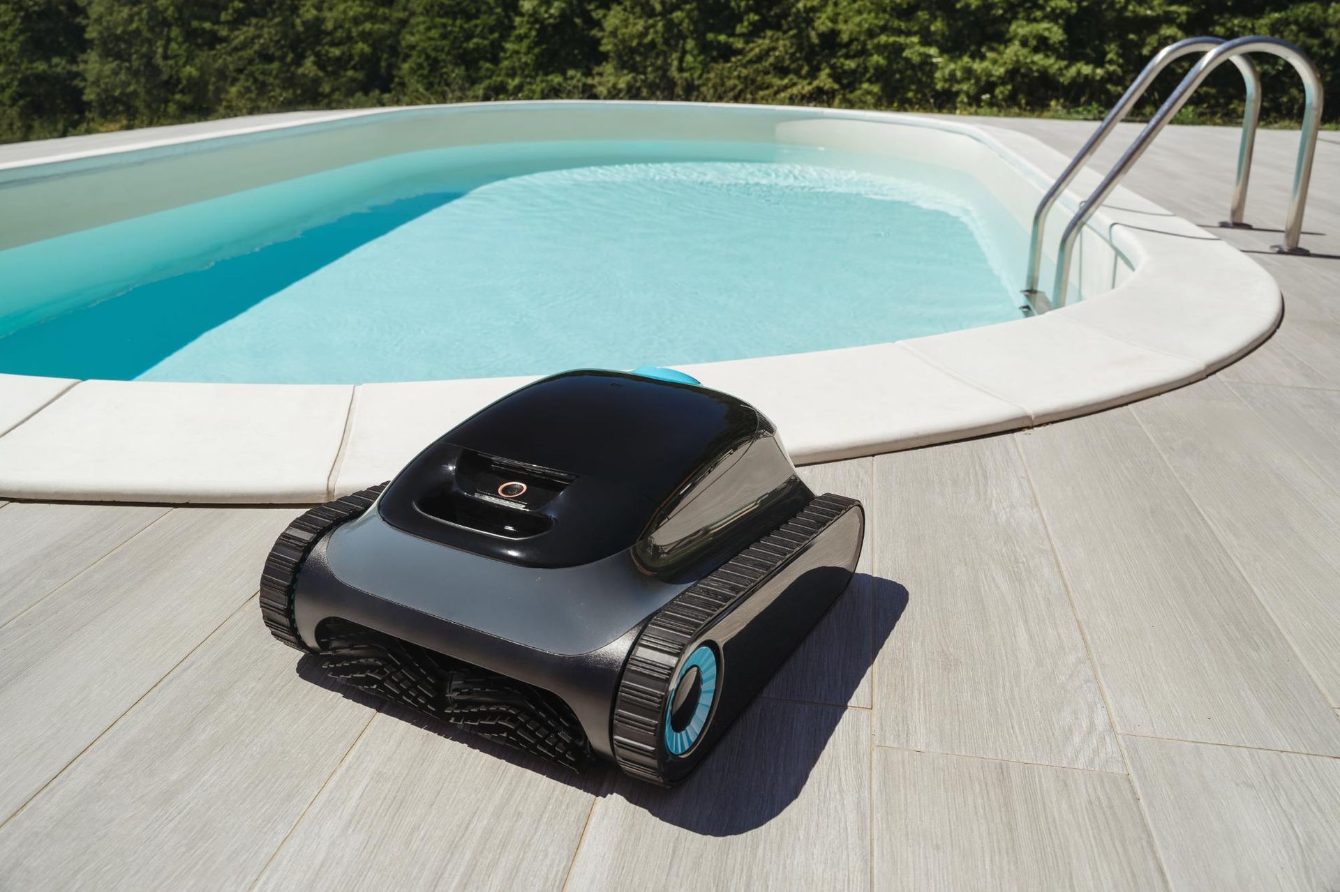 Pool cleaning robot on a deck beside a light blue pool, sunny day.
