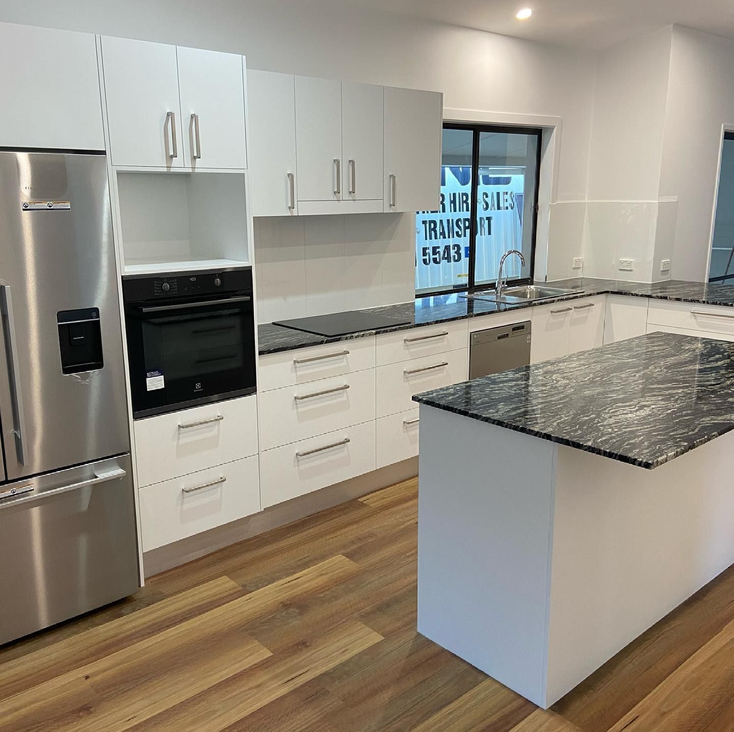 A Kitchen with Stainless Steel Appliances , White Cabinets , Granite Counter Tops , and a Large Island — Expert Cabinetmaker on the Sunshine Coast QLD
