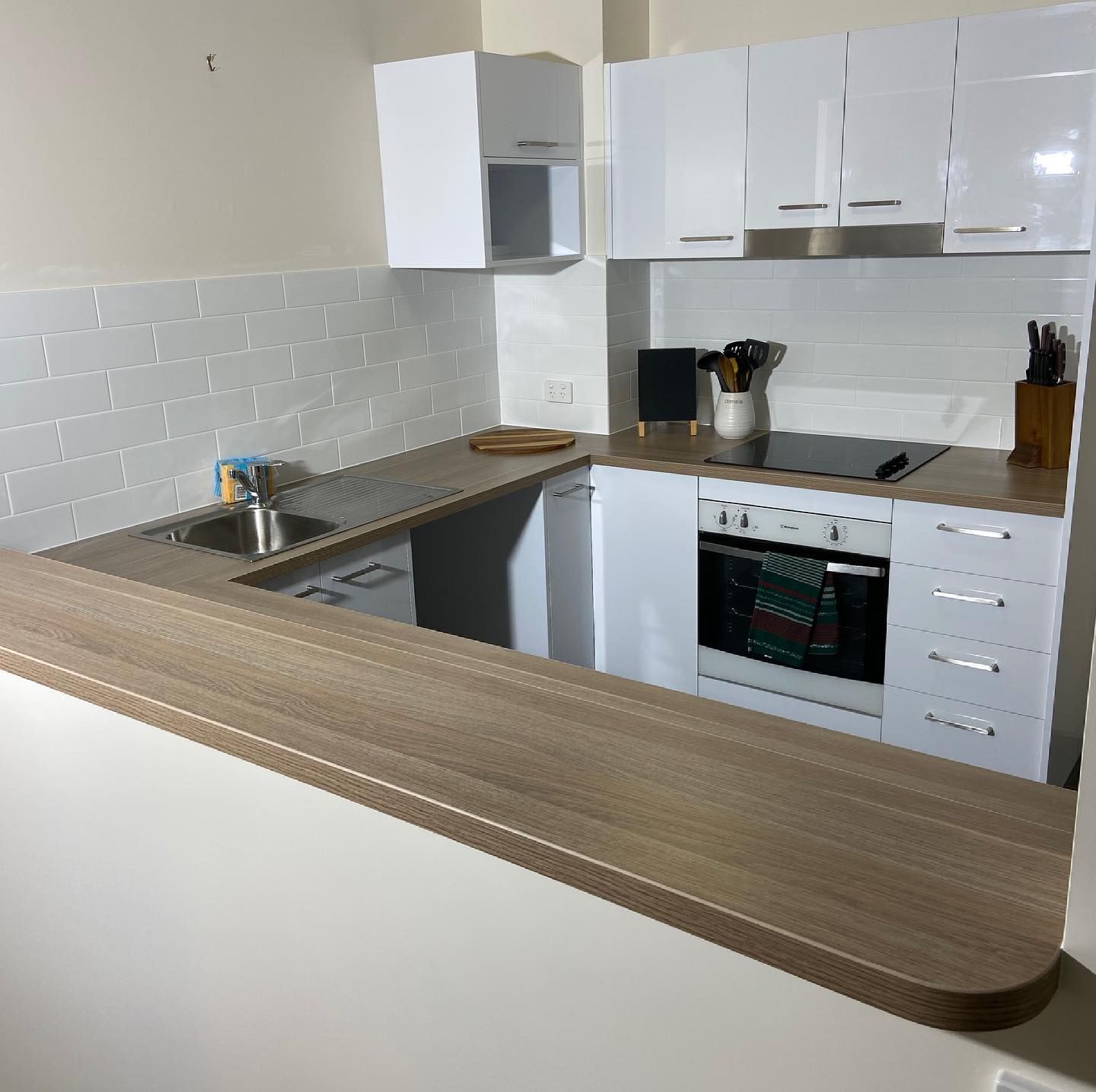 A Kitchen with White Cabinets and a Wooden Counter Top — Expert Cabinetmaker on the Sunshine Coast QLD