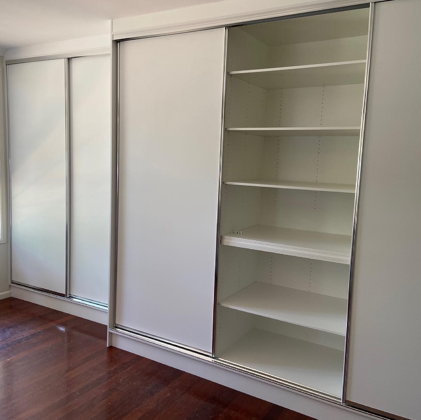 A Closet with Sliding Doors and Shelves in a Room — Expert Cabinetmaker on the Sunshine Coast QLD