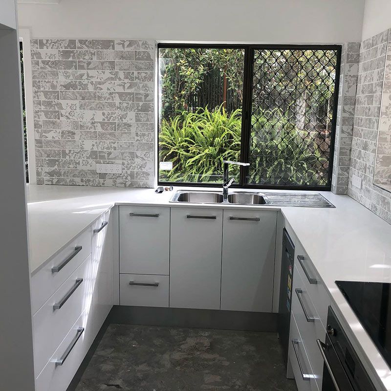 A Kitchen with White Cabinets, Sink, and Window — Expert Cabinetmaker on the Sunshine Coast QLD