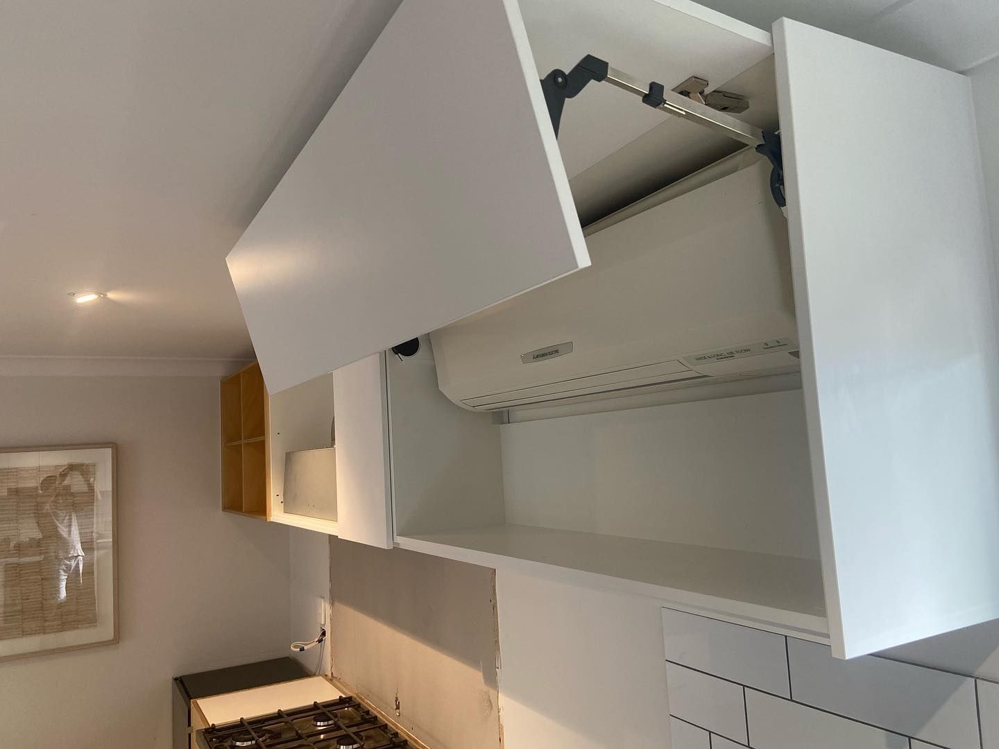A Kitchen featuring White Cabinetry and Wall Art — Expert Cabinetmaker on the Sunshine Coast QLD