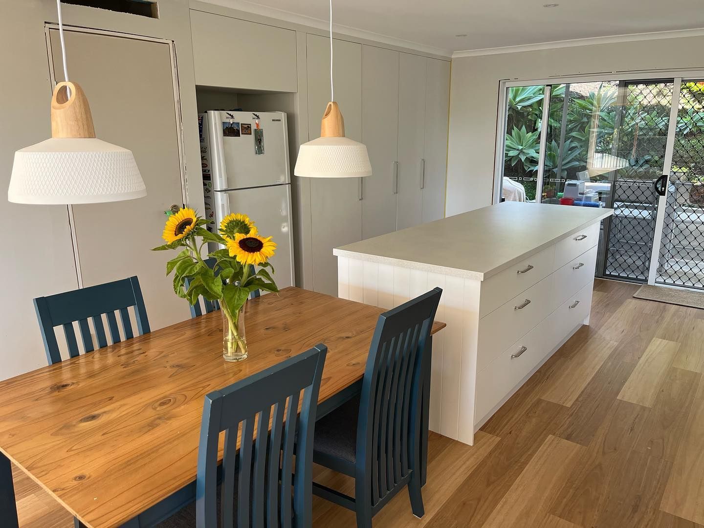 A Dining Room Table Adorned With a Vase of Sunflowers — Expert Cabinetmaker on the Sunshine Coast QLD