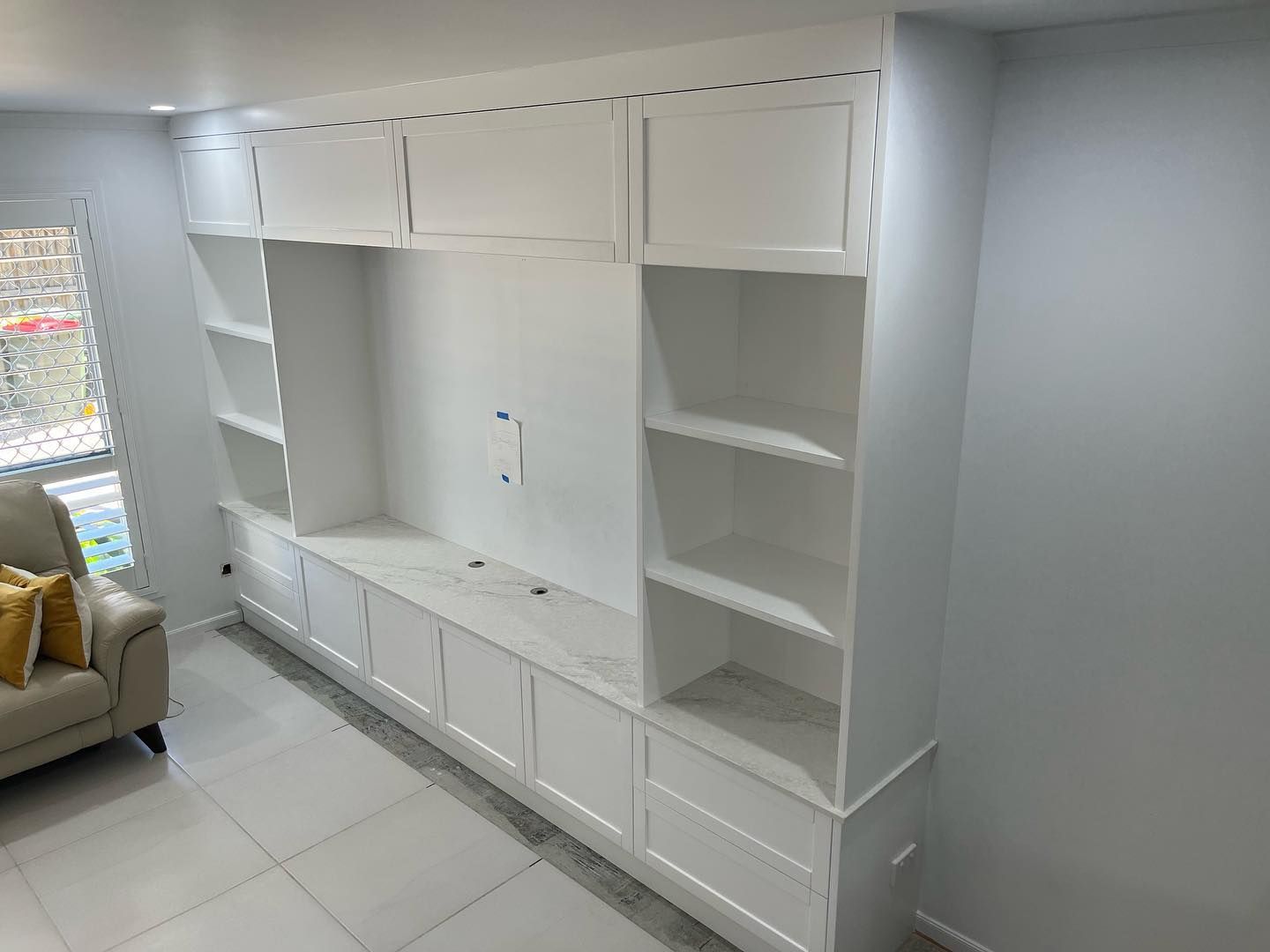 A Cosy Living Room Featuring a Couch, Shelves, and Cabinets — Expert Cabinetmaker on the Sunshine Coast QLD