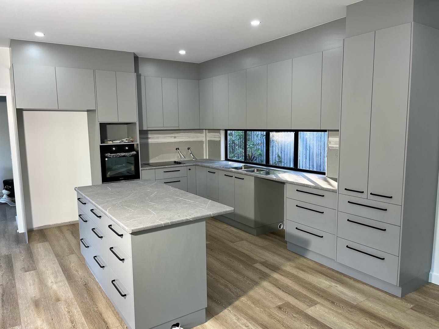 A Kitchen with Grey Cabinets and a Spacious Island Centre — Expert Cabinetmaker on the Sunshine Coast QLD