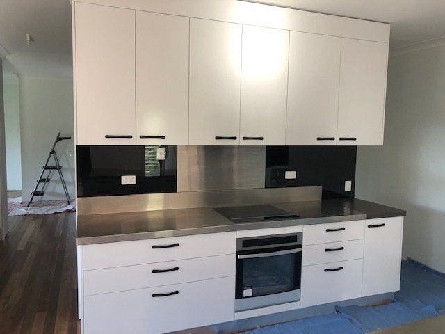 A Kitchen with White Cabinets and Stainless Steel Countertops — Expert Cabinetmaker on the Sunshine Coast QLD