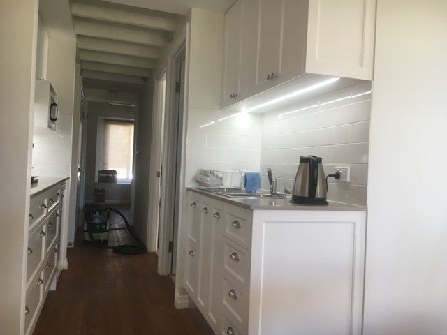 A Kitchen with White Cabinets, Sink, and Kettle — Expert Cabinetmaker on the Sunshine Coast QLD