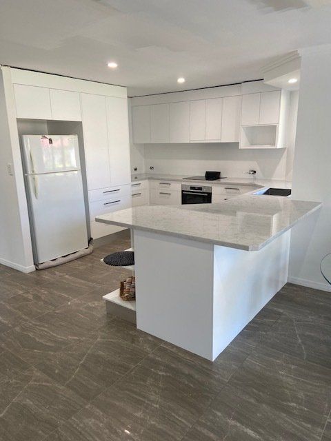 A Kitchen Featuring White Cabinetry, a Refrigerator, and a Spacious Island — Expert Cabinetmaker on the Sunshine Coast QLD
