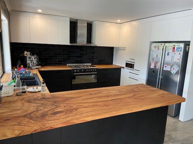 A Kitchen with Black Cabinets and a Wooden Countertop — Expert Cabinetmaker on the Sunshine Coast QLD
