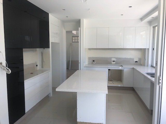 A Kitchen with Black and White Cabinets and a Spacious Island — Expert Cabinetmaker on the Sunshine Coast QLD
