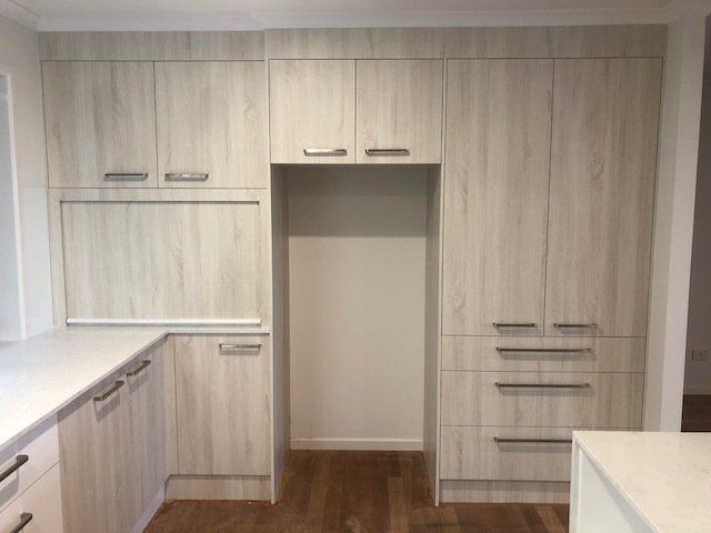 A Kitchen with White Cabinets and Wooden Floors, Exuding Classic Elegance — Expert Cabinetmaker on the Sunshine Coast QLD