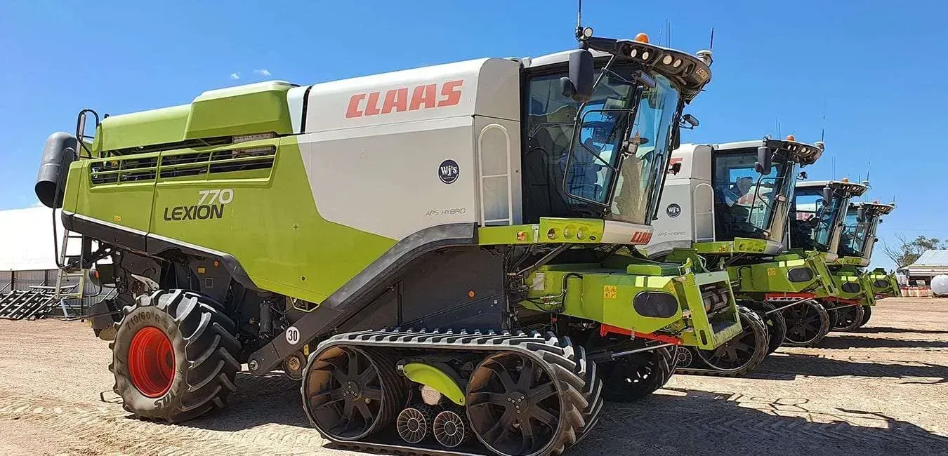 A Row of Claas Tractors Are Parked in a Dirt Field — Dynamic Performance Systems In Kelso, NSW