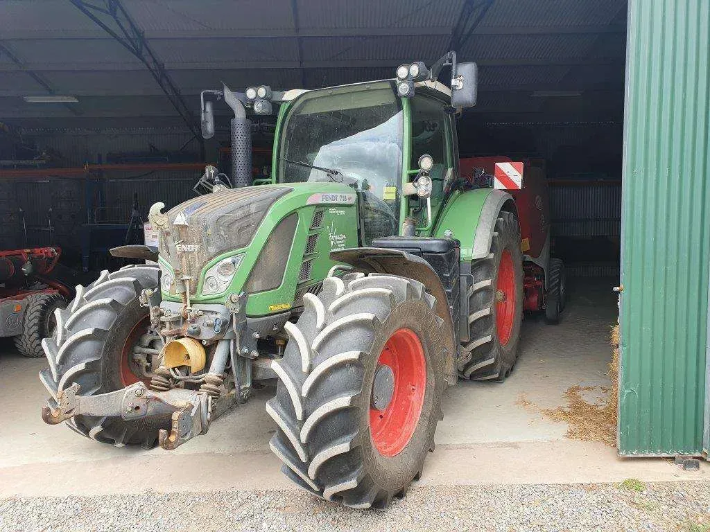 A Green and Red Tractor is Parked in Front of a Green Building — Dynamic Performance Systems In Kelso, NSW