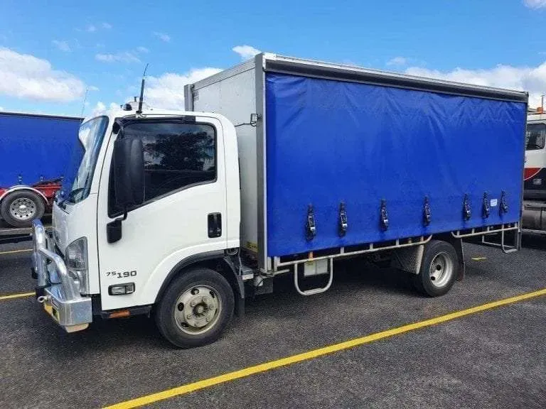 A White Truck With a Blue Tarp is Parked in a Parking Lot — Dynamic Performance Systems In Kelso, NSW
