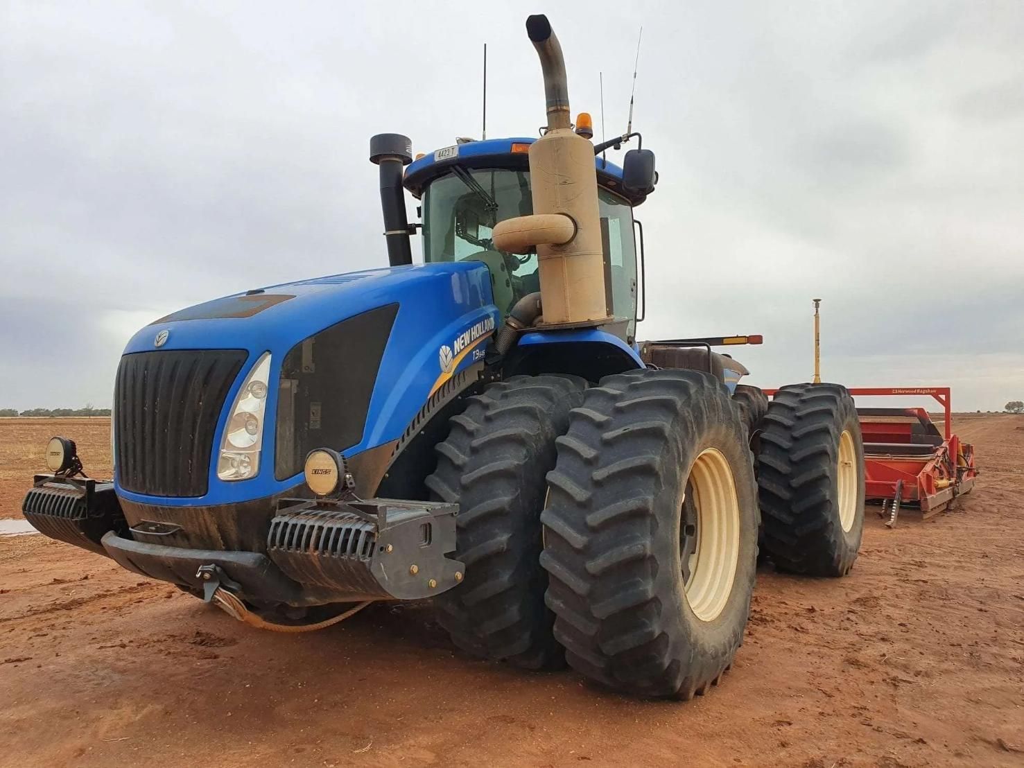 A Blue Tractor is Parked in a Dirt Field — Dynamic Performance Systems In Kelso, NSW