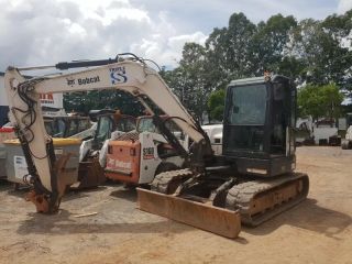 A Bobcat Excavator is Parked in a Dirt Lot — Dynamic Performance Systems In Kelso, NSW