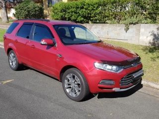 A Red Car is Parked on the Side of the Road — Dynamic Performance Systems In Kelso, NSW
