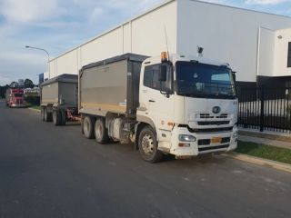 A Dump Truck is Parked on the Side of the Road Next to a Building — Dynamic Performance Systems In Kelso, NSW
