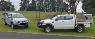 Two White Trucks Are Parked Next to Each Other on the Side of the Road — Dynamic Performance Systems In Kelso, NSW